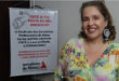 foto da nova presidenta do sindicato dos jornalistas à frente de cartaz de convocação para a sindicalização