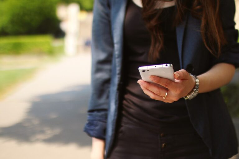mulher acessa informações no celular enquanto caminha Foto: Pìxabay